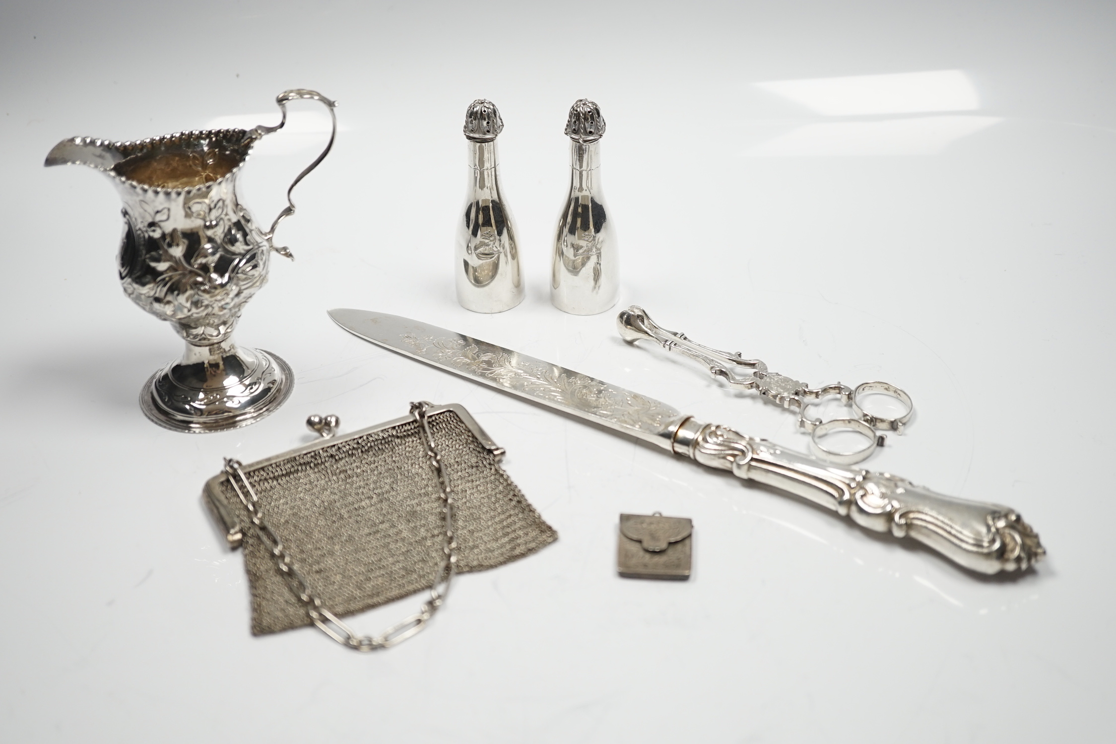 A George III silver inverted pear shaped cream jug, with later embossed decoration, London, 1774, a pair of late Victorian bottle shaped pepperettes and other small silver.